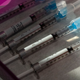 Five vaccine syringes on a tray